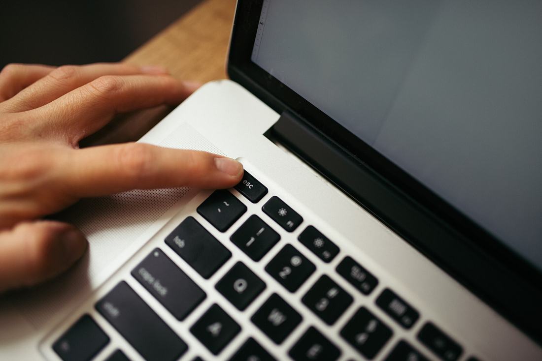 Hand an einer Laptop-Tastatur